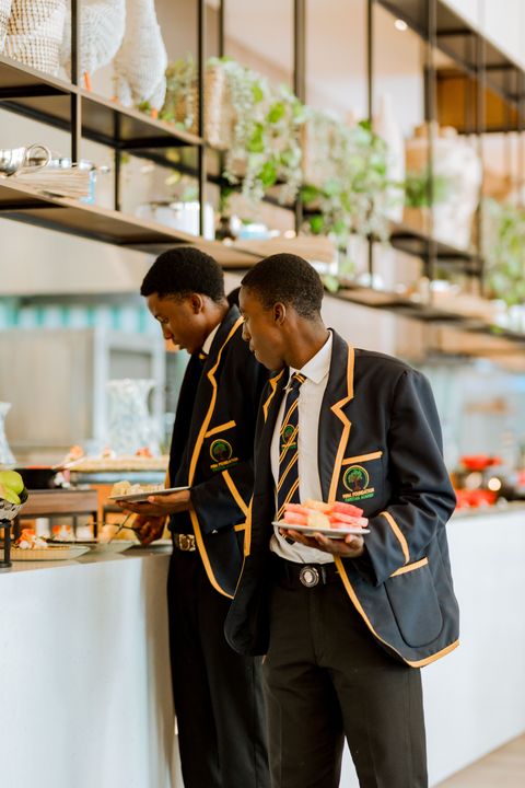 Learners in school uniform at the buffet during the hotel outing