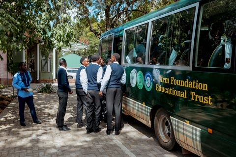 Learners beside the bus carrying the Firm Foundation name after the outing