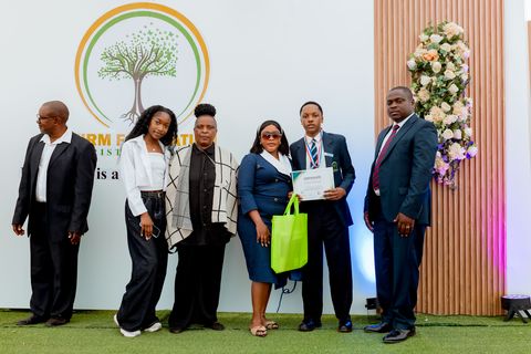 Award recipients and presenters beside the Firm Foundation school backdrop