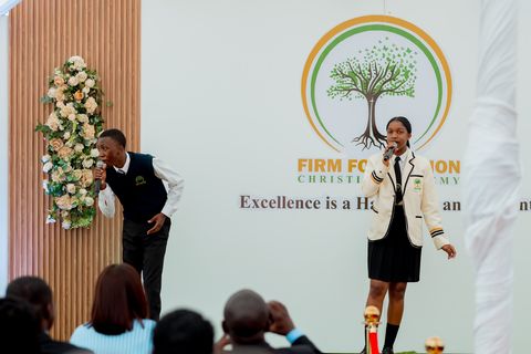 Learners performing in front of the Firm Foundation backdrop at prize giving