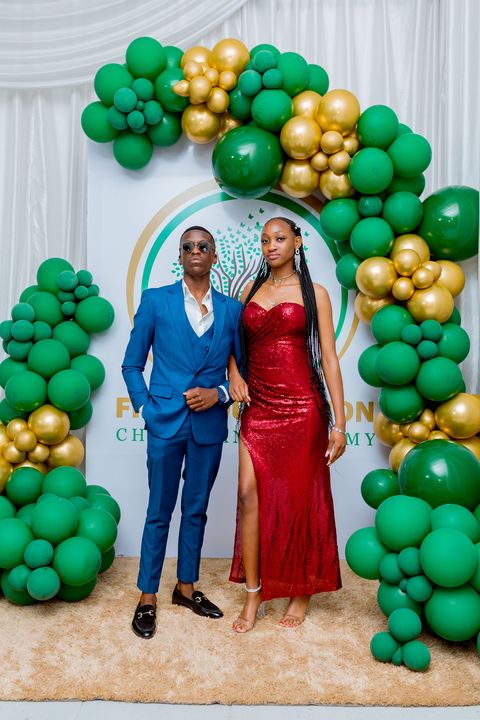 Prom guests posing beside the Firm Foundation backdrop