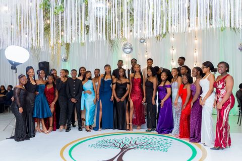 Prom guests posing together above the Firm Foundation logo on the dance floor