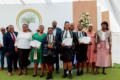 Uniformed Firm Foundation award recipients in front of the school logo