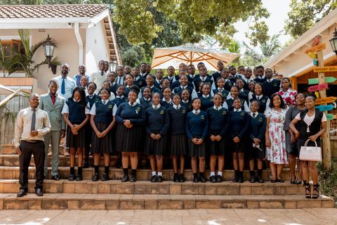 Uniformed Firm Foundation learners and staff gathered outside the restaurant on a school outing