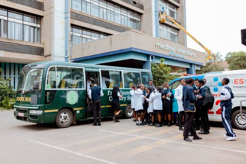 Learners and the school bus outside CIMAS during an off-campus educational visit