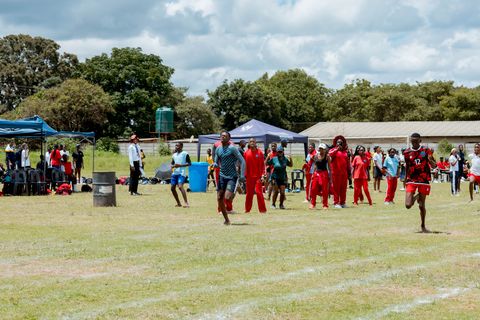 Learners crossing the sports field with school buildings in view