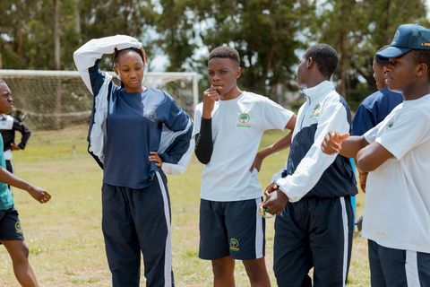 Learners in school sports uniforms spending time together on the field