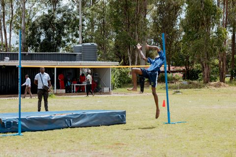 A learner taking part in high jump on the school grounds