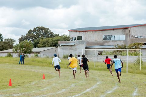Learners racing past campus buildings during sports day